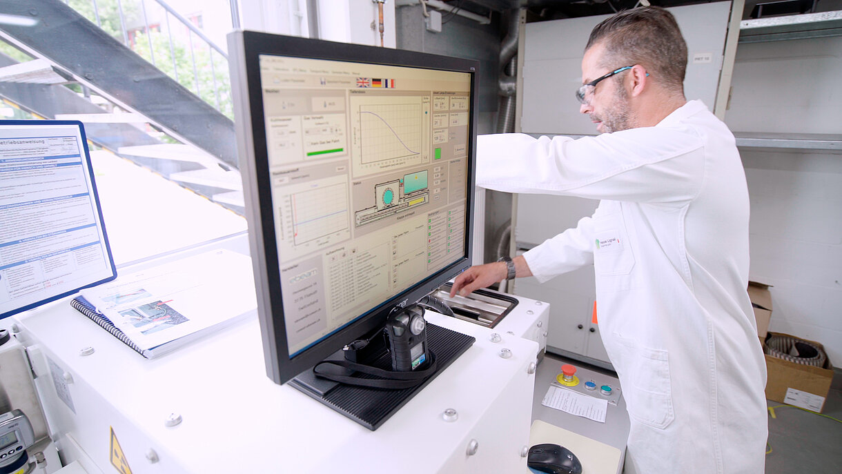 Munkaruhás férfi egy elektronsugaras térhálósító berendezés előtt